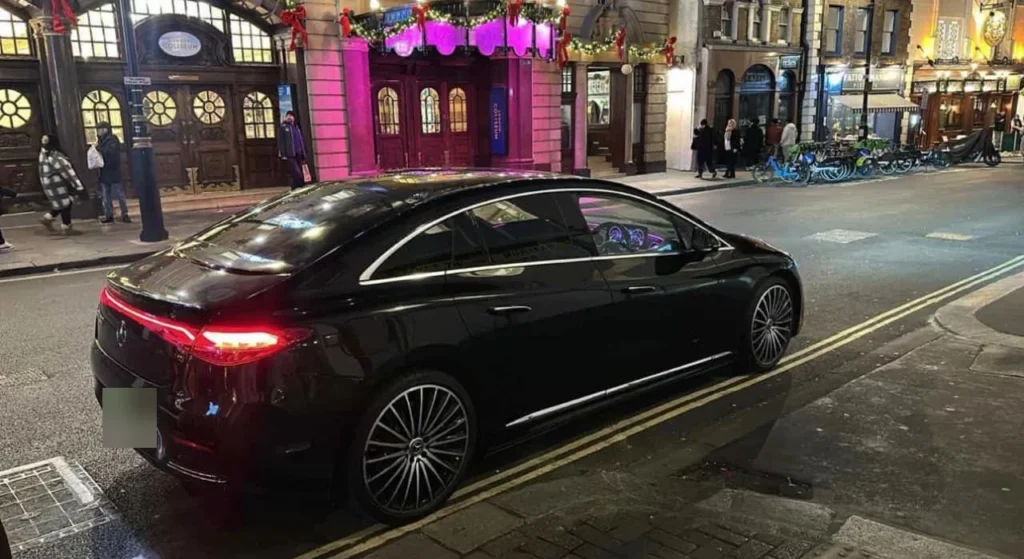 Black luxury Mercedes chauffeur saloon parked outside the London Coliseum in the West End at night