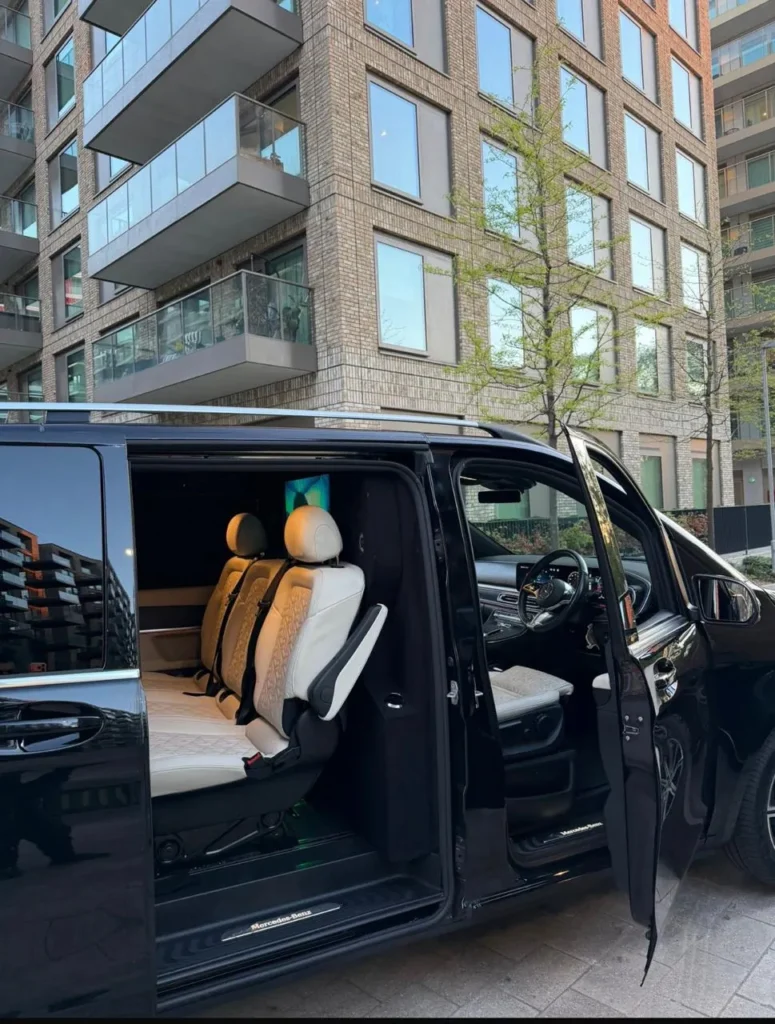 Black Mercedes V-Class executive MPV parked in London with doors open showing cream leather passenger seats