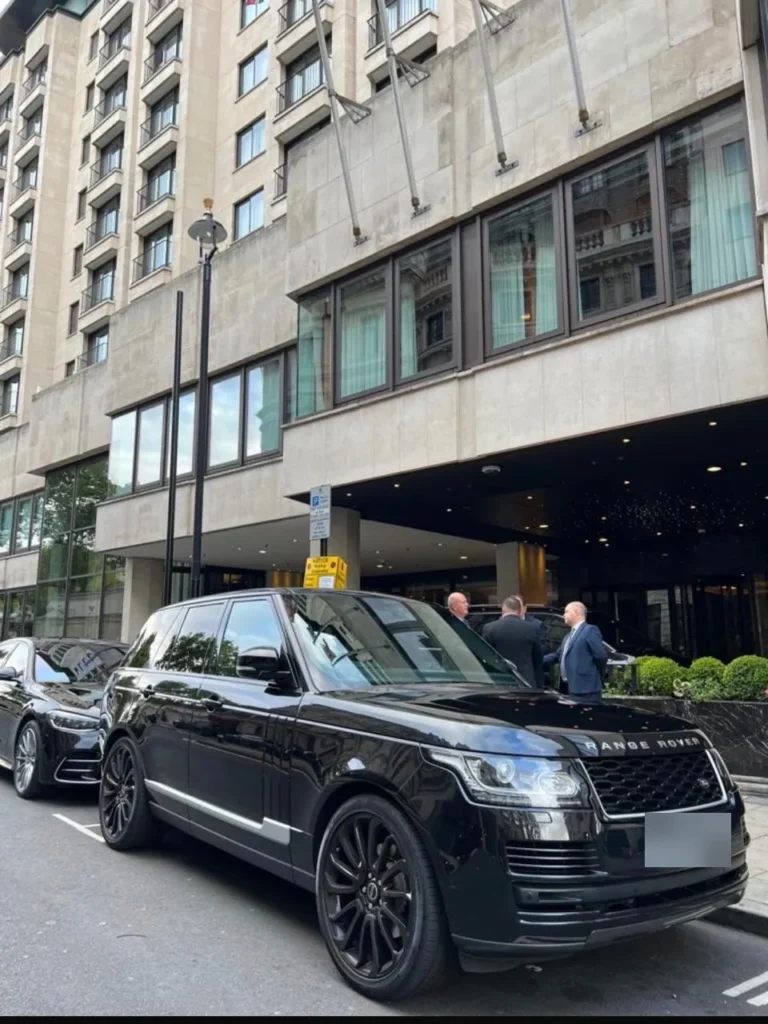 Black Range Rover Vogue chauffeur car waiting outside a luxury London hotel