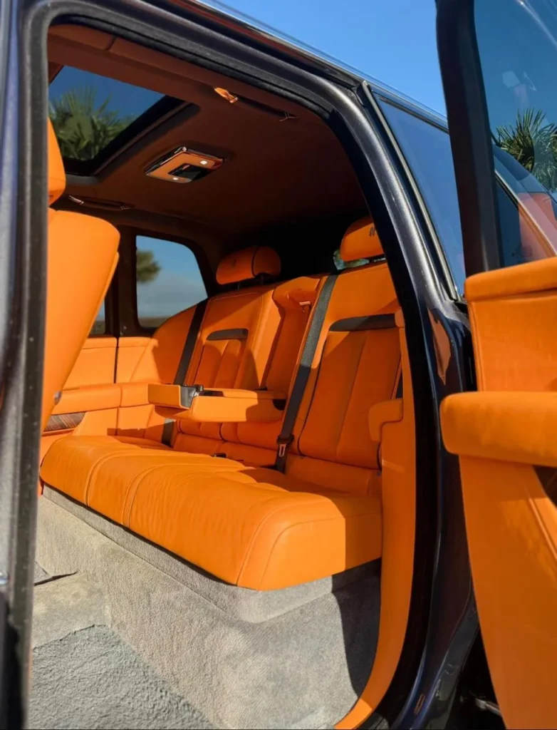 Rolls-Royce Cullinan rear passenger cabin with bespoke orange leather seats and sunroof